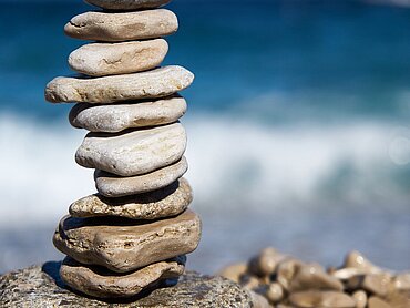 Übereinandergestapelte Steine am Meer.