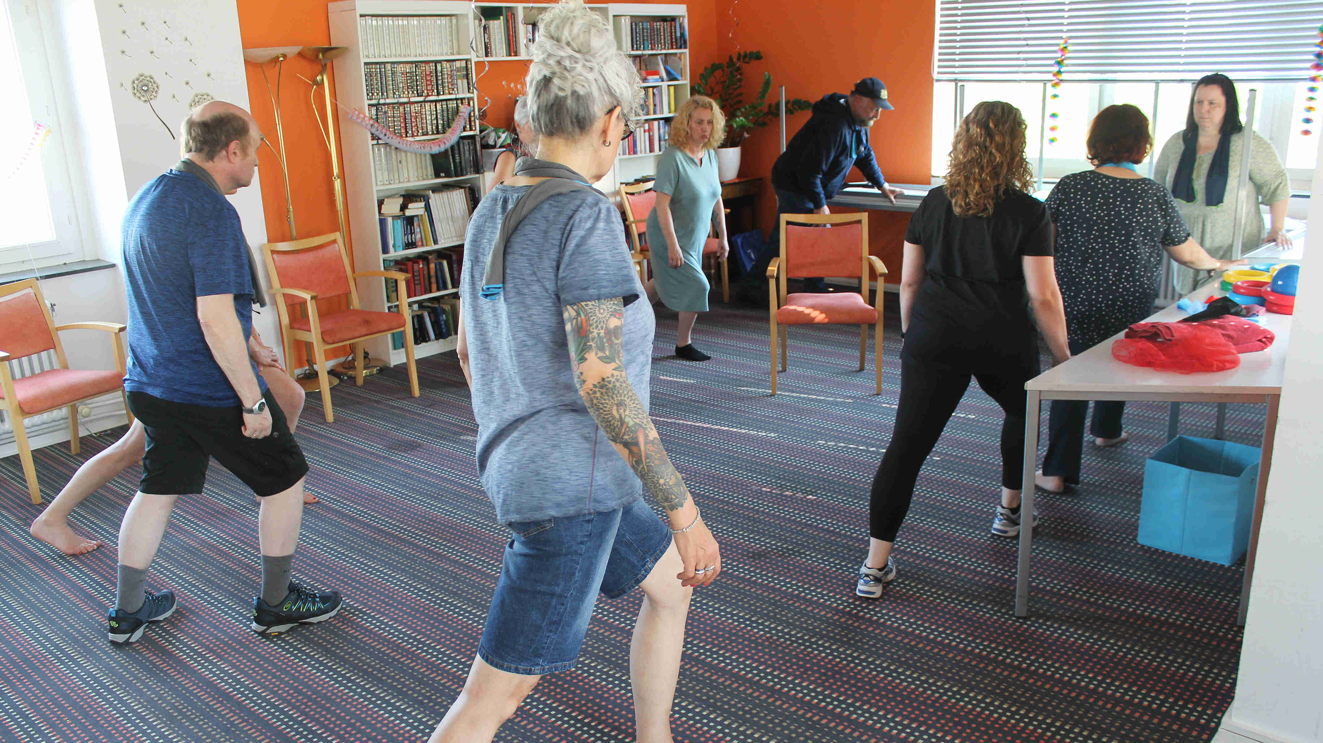 Menschen in einem Raum machen einen Ausfallschritt.