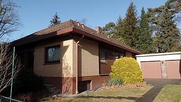 Ein Haus und daneben zwei Garagentore.