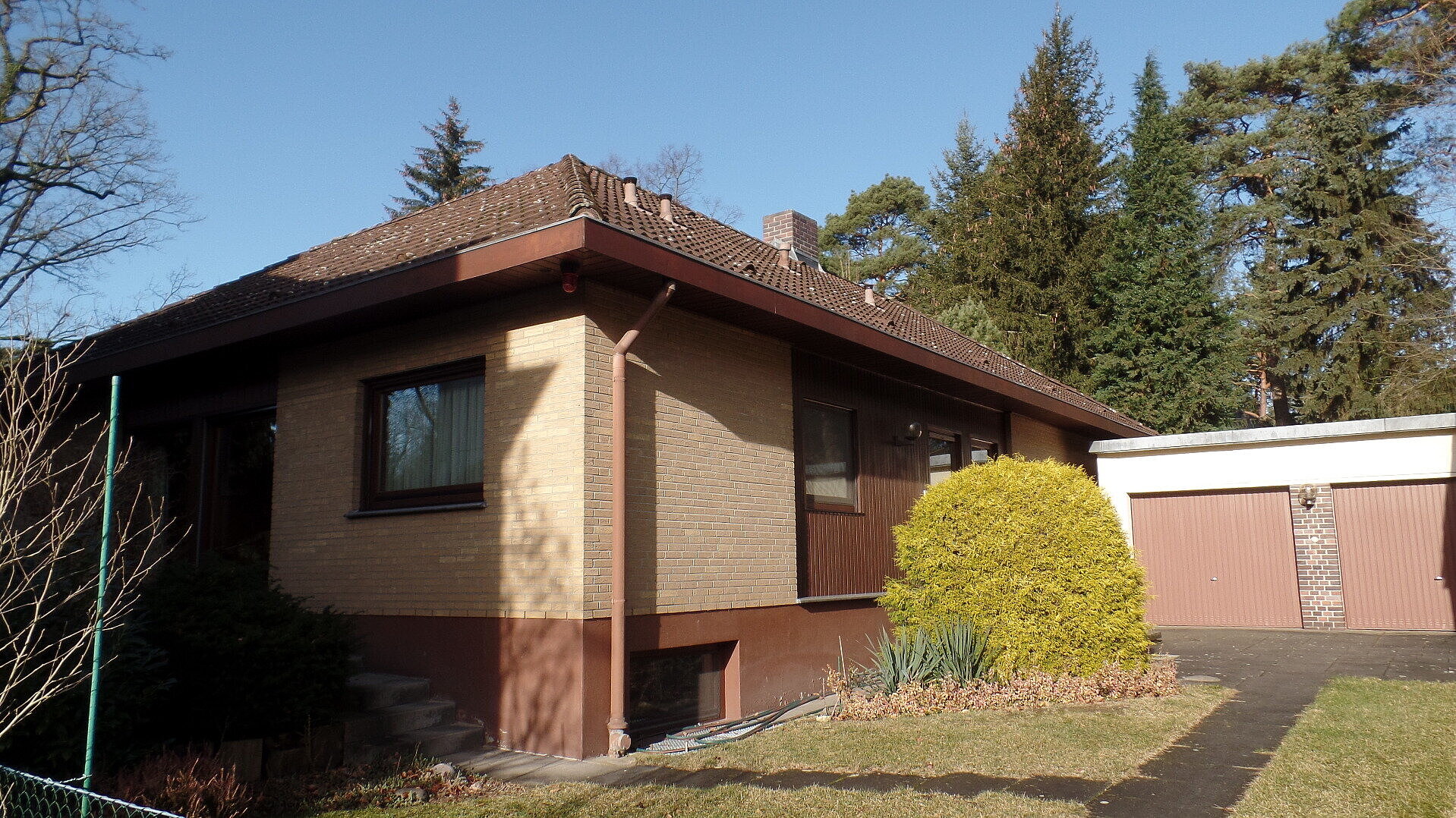 Ein Haus und daneben zwei Garagentore.