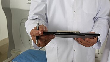 Ein Arzt vor einem Tomographen. 