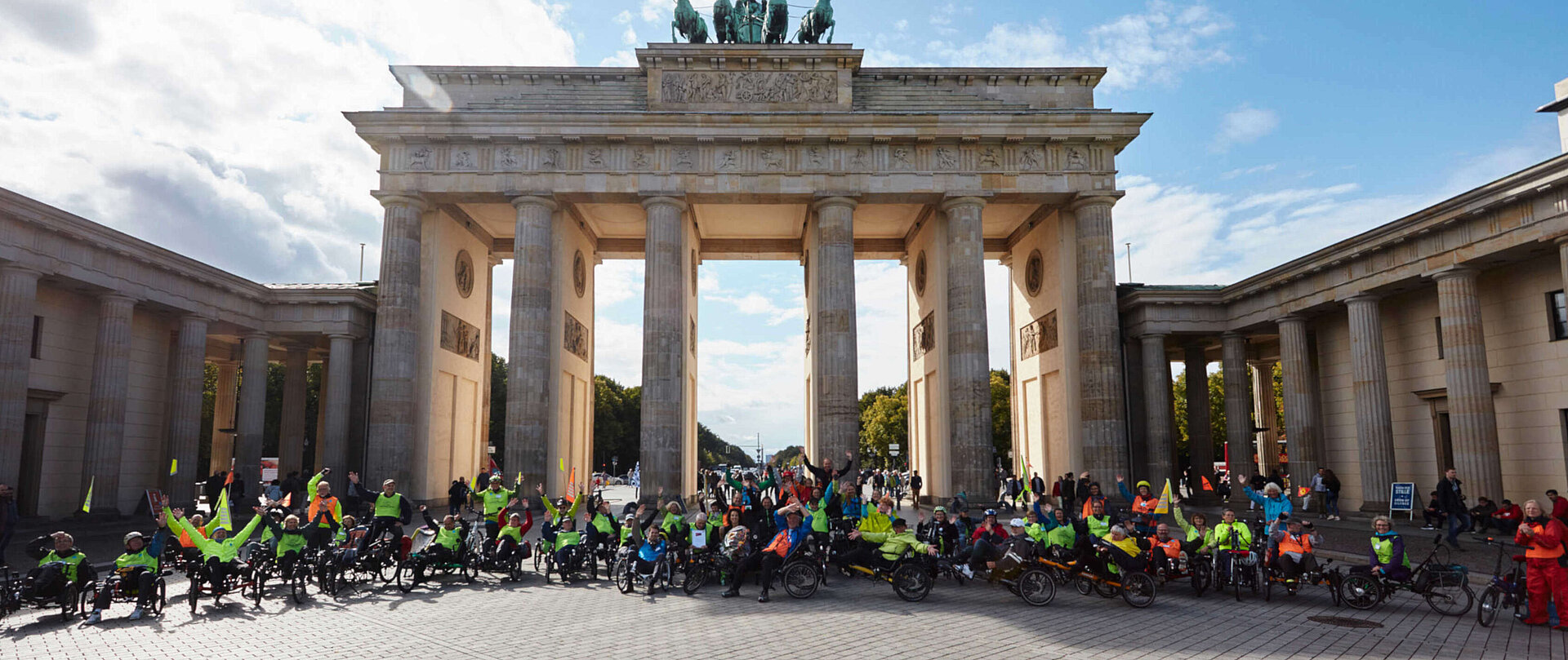 Gruppenfoto von Menschen auf Fahrrädern vor dem Brandenburger Tor.