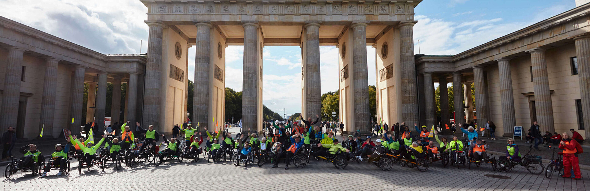 Gruppenfoto von Menschen auf Fahrrädern vor dem Brandenburger Tor.