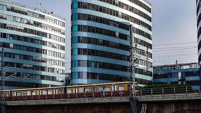 S-Bahn vor zwei Hochhäusern.