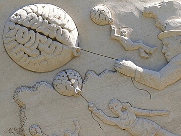 Ein Gehirn in eine Marmorwand gemeißelt.