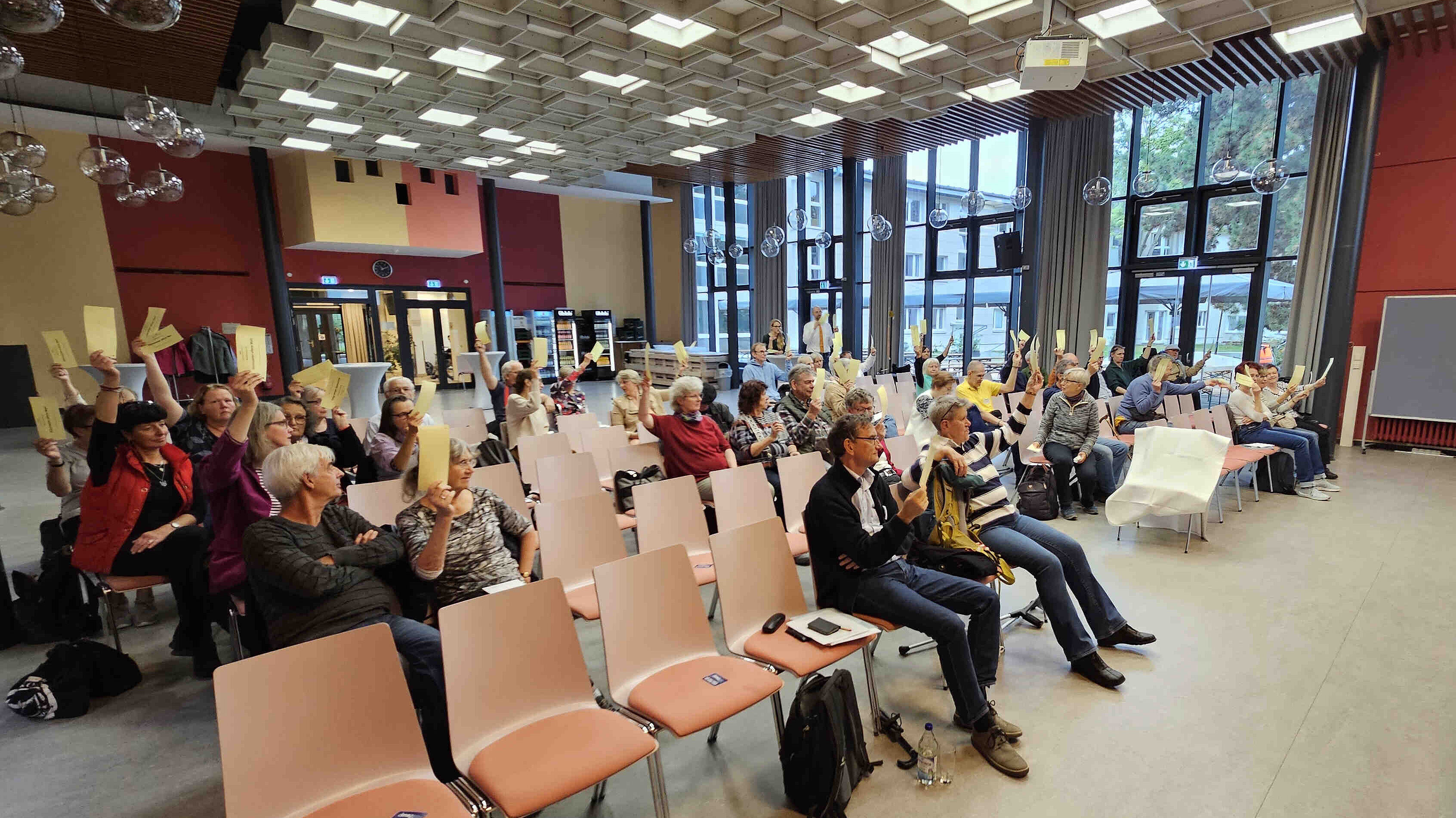 Menschen, die Abstimmungszettel hochhalten.