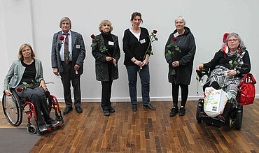 Ein Gruppenfoto vor einer weißen Wand. 