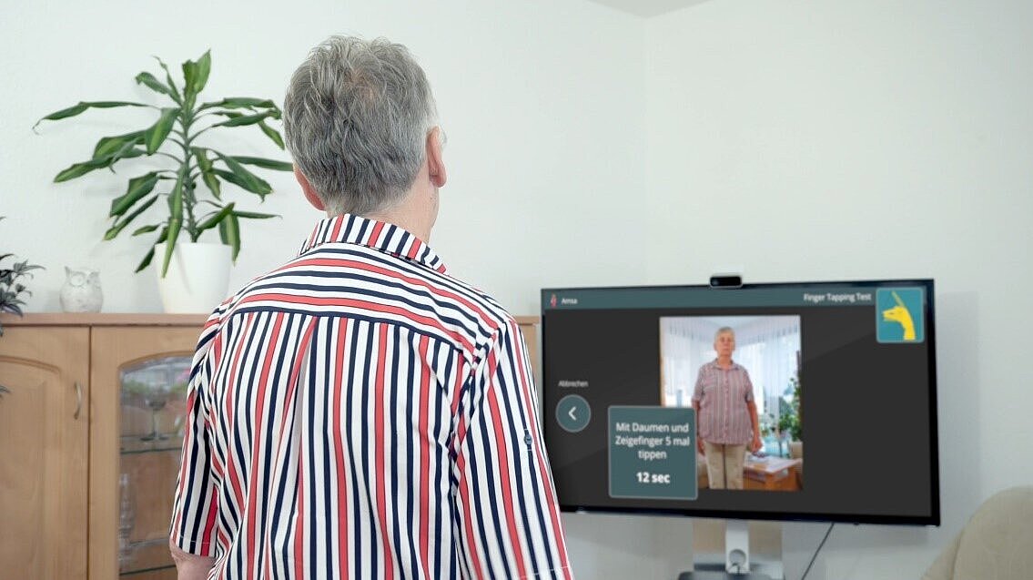 Ein Mann steht vor einem Bildschirm.