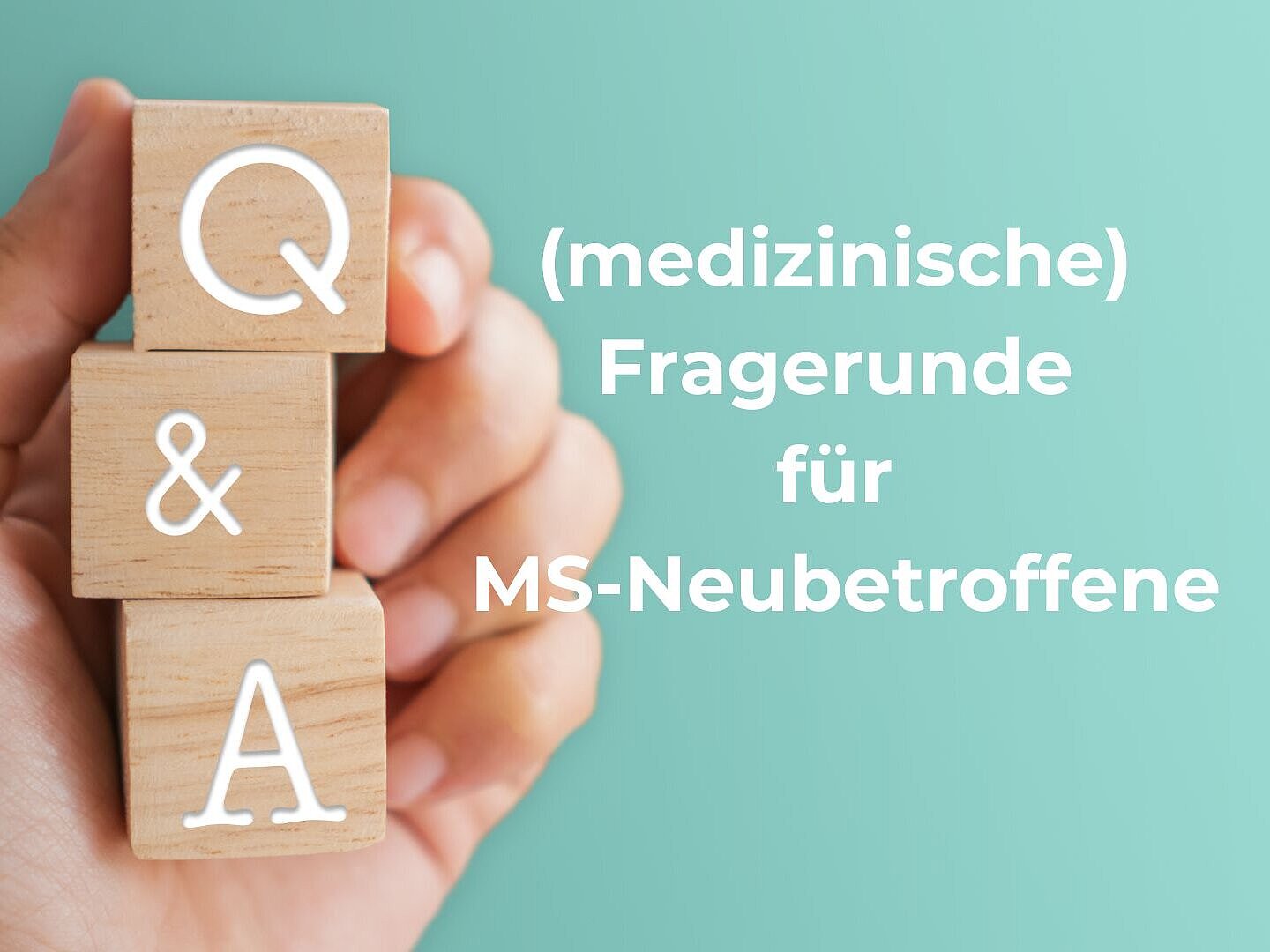Eine Hand hält drei Holzwürfel mit den Buchstaben "Q", "&" und "A".